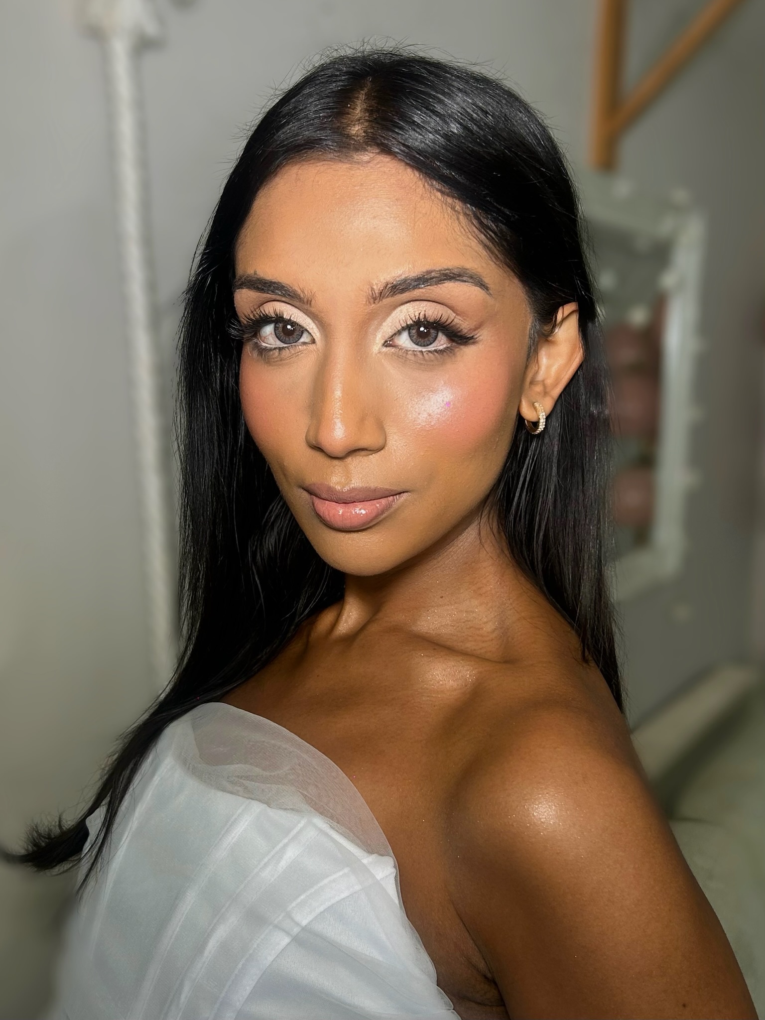 Glam makeup with bronzed dewy skin and defined lashes